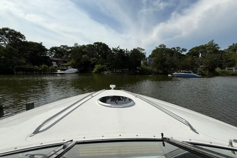 Slide: The Image of Bow view of 2013 Cobalt 323 boat on a serene lake with surrounding trees. - 15