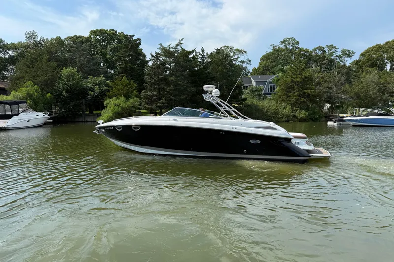 Slide: The Image of 2013 Cobalt 323 boat on a serene lake, surrounded by lush greenery. - 2