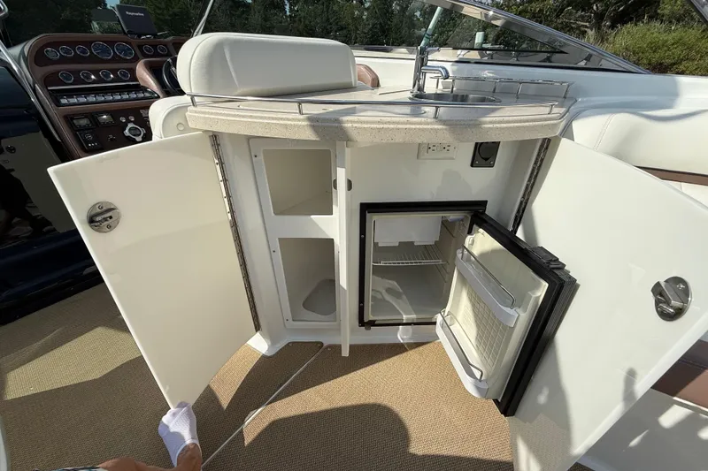 Slide: The Image of 2013 Cobalt 323 boat interior with open cabinets and mini fridge. - 6
