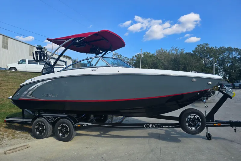 The Image of 2019 Cobalt R3 Surf boat on trailer, gray hull, red canopy, outdoors. - 0