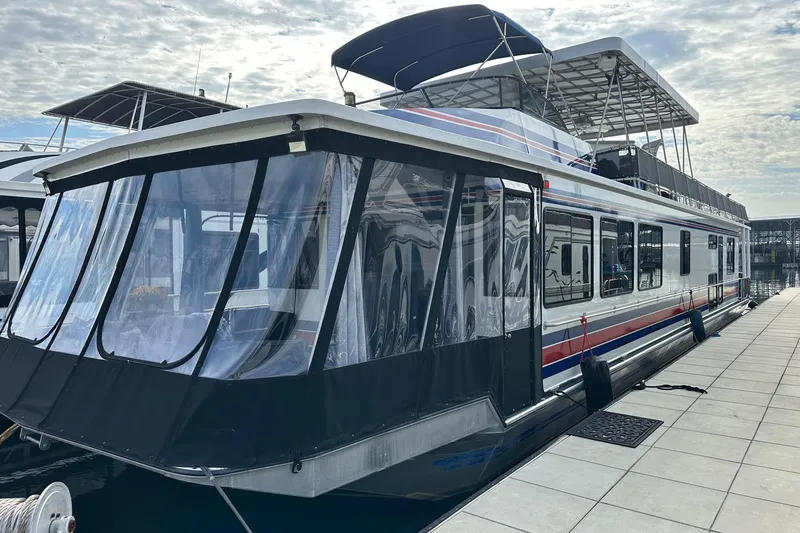The Image of 1995 Stardust Cruisers 16x75 houseboat docked under a cloudy sky. - 0