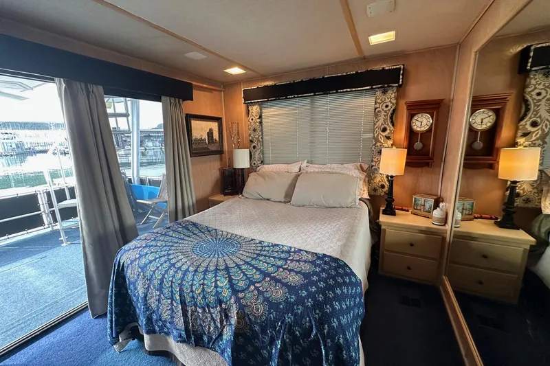 Slide: The Image of Cozy bedroom in 1995 Stardust Cruisers 16x75 houseboat with nautical decor and waterfront view. - 10