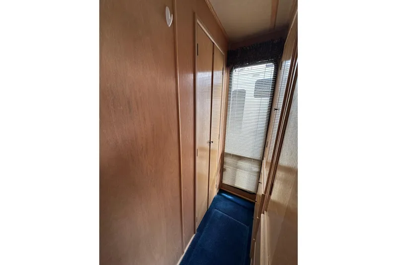 Slide: The Image of Narrow hallway in 1995 Stardust Cruisers 16x75 houseboat with wooden walls and blue carpet. - 11