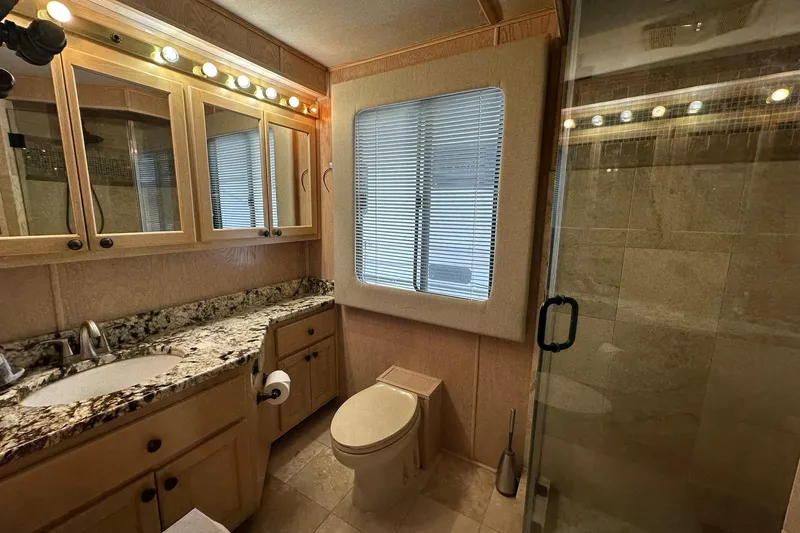 Slide: The Image of Luxurious bathroom in 1995 Stardust Cruisers 16x75 houseboat with granite countertop and glass shower. - 12