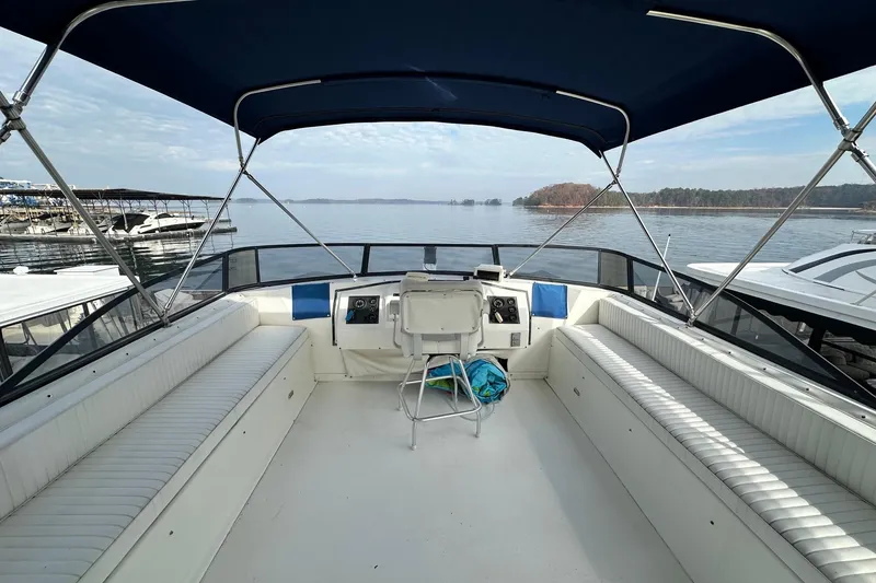 Slide: The Image of 1995 Stardust Cruisers 16x75 houseboat deck with seating, helm, and lake view. - 14