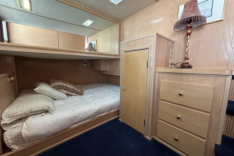 Slide: The Image of Cozy bedroom in 1995 Stardust Cruisers 16x75 houseboat with wooden cabinetry and soft lighting. - 6