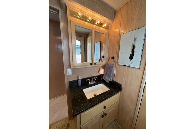 Slide: The Image of Bathroom vanity in 1995 Stardust Cruisers 16x75 houseboat with mirror and abstract wall art. - 8