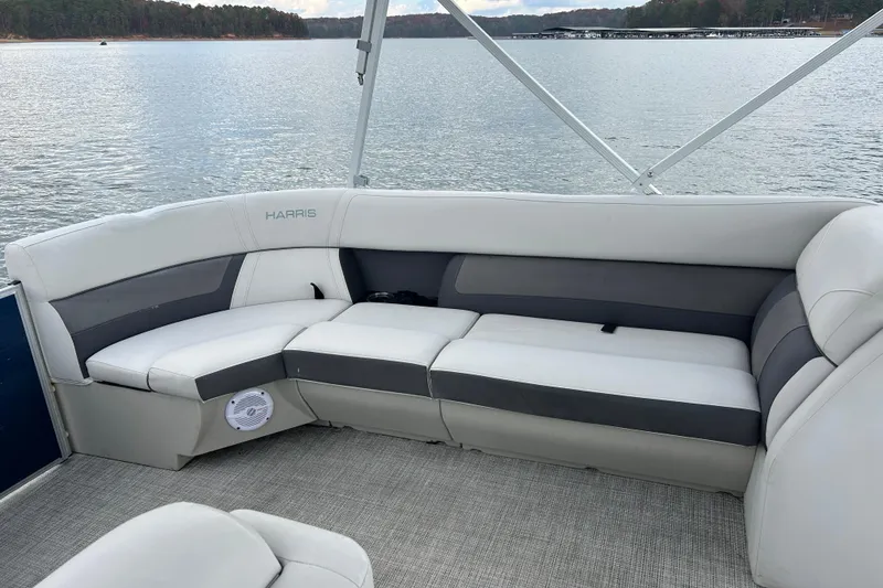 Slide: The Image of 2023 Harris Cruiser 230 boat interior with gray seating, lake view. - 13