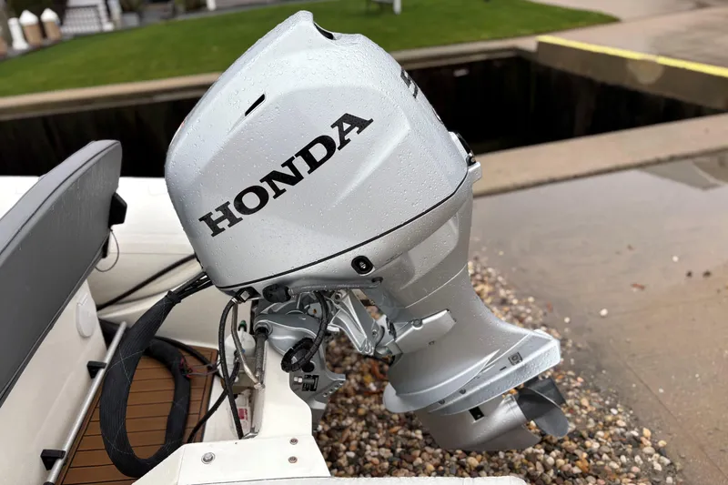Slide: The Image of Honda outboard motor on 2022 Brig Falcon Tender 420 boat, docked on a rainy day. - 4