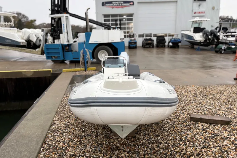Slide: The Image of 2022 Brig Falcon Tender 420 boat on gravel near a marine service center. - 8