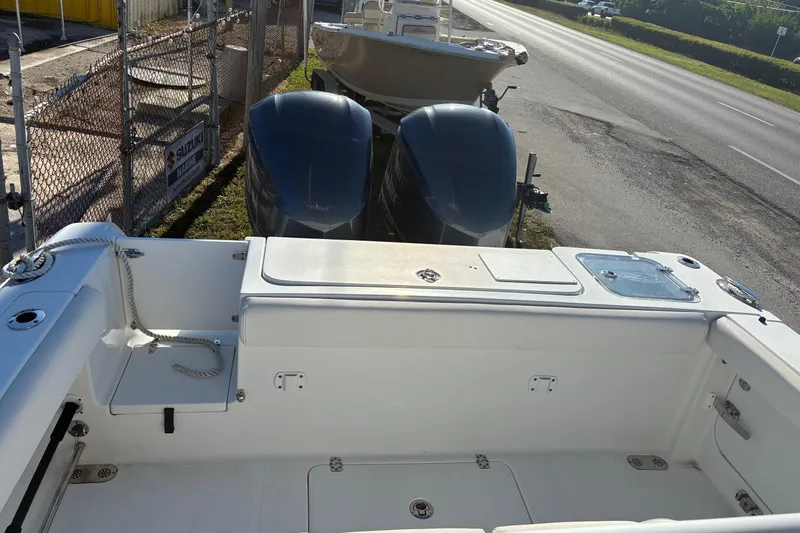 Slide: The Image of 2019 Sea Hunt Gamefish 27 boat with dual engines, parked near a road. - 4