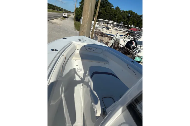 Slide: The Image of 2019 Sea Hunt Gamefish 27 boat interior with seating, parked near a road. - 6