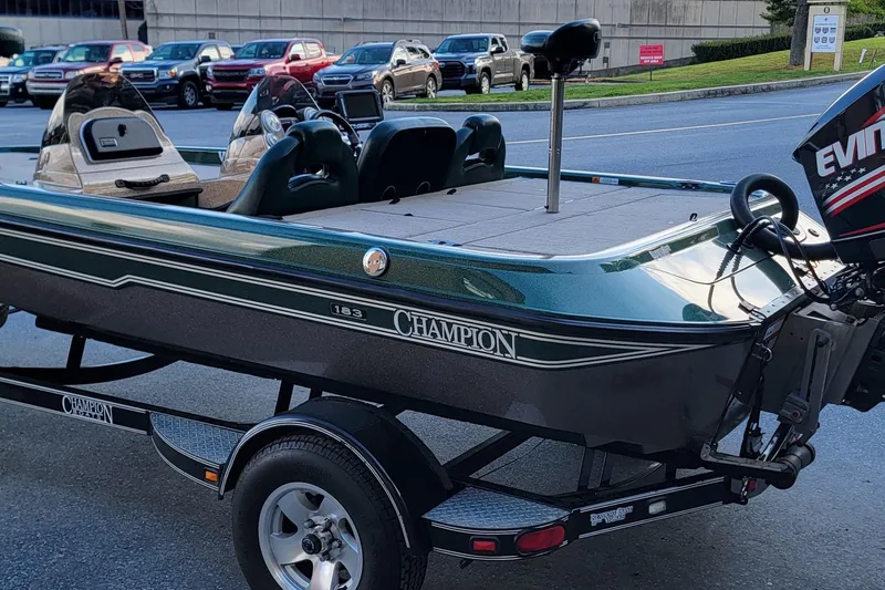 Slide: The Image of 2008 Champion 183 CX boat on trailer, parked on street with Evinrude motor. - 11