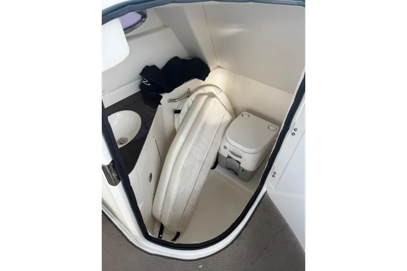 Slide: The Image of 2013 Sea Ray 300 Sundeck interior with compact bathroom and sink. - 18