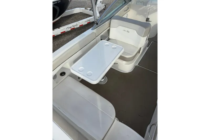 Slide: The Image of 2013 Sea Ray 300 Sundeck interior with seating and table setup. - 23