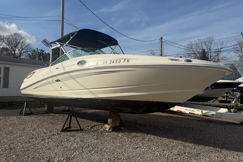 Slide: The Image of 2013 Sea Ray 300 Sundeck boat on stands, parked outdoors on gravel. - 33