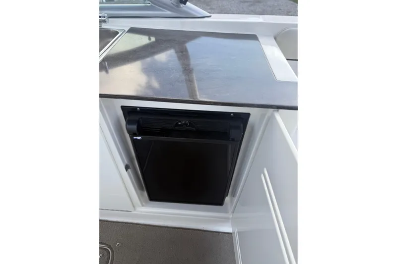 Slide: The Image of 2013 Sea Ray 300 Sundeck boat kitchenette with countertop and mini fridge. - 4