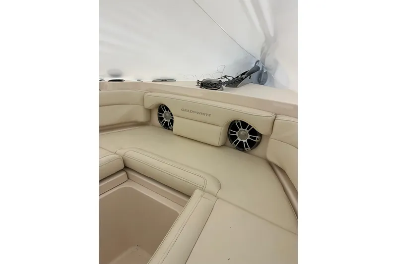 Slide: The Image of 2024 Grady-White Freedom 235 boat interior with beige seating and built-in speakers. - 3