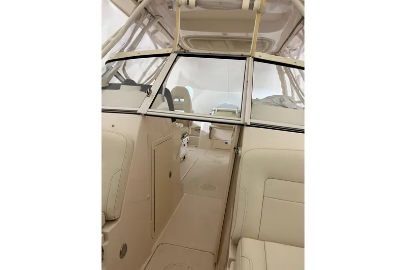Slide: The Image of 2024 Grady-White Freedom 235 boat interior with beige seating and windshield. - 4