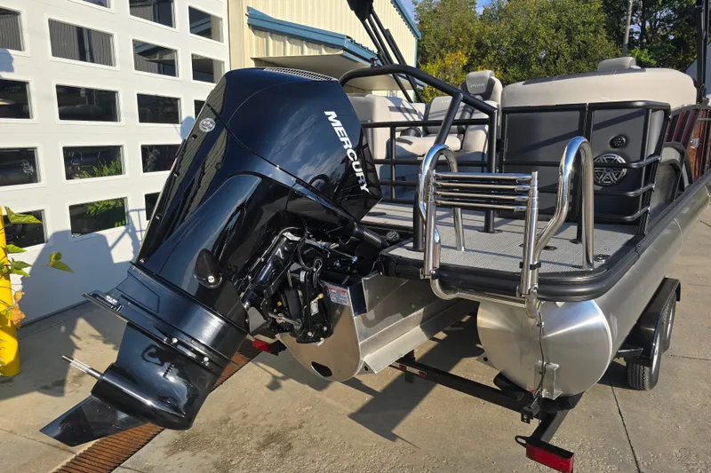 Slide: The Image of 2024 Sylvan L3 LZ pontoon boat with Mercury outboard motor, docked outdoors. - 5