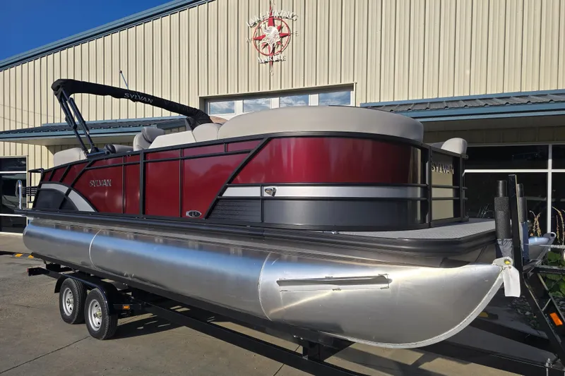 Slide: The Image of 2024 Sylvan L3 LZ pontoon boat with sleek red and silver design on trailer. - 9