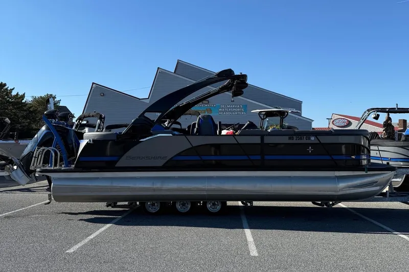 The Image of 2024 Berkshire 25RFX STS pontoon boat parked in a lot under clear blue sky. - 0