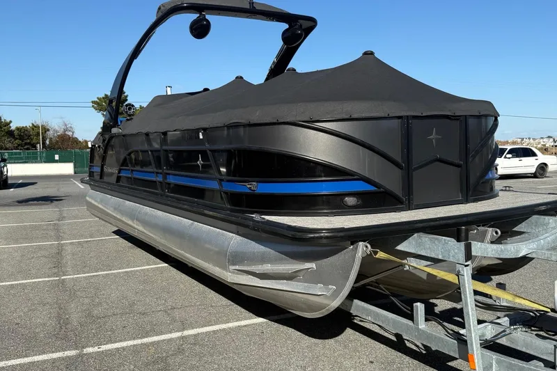 Slide: The Image of 2024 Berkshire 25RFX STS pontoon boat with outboard motor, parked in a lot. - 6