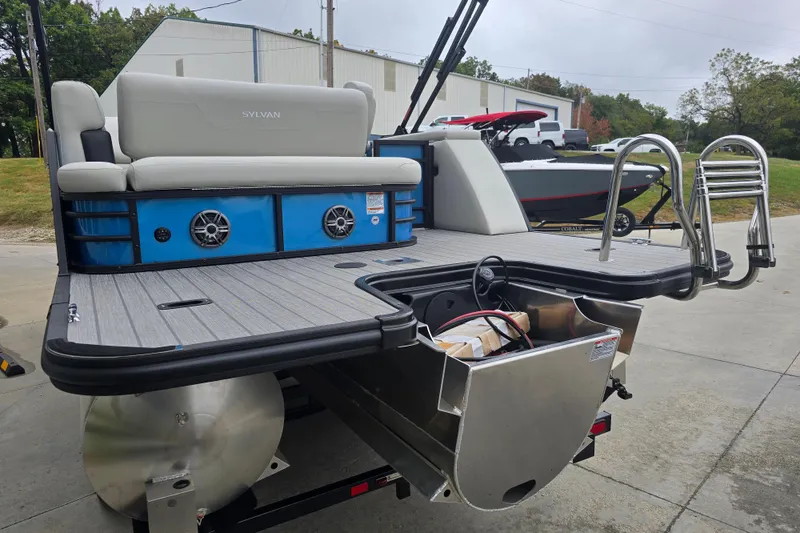 Slide: The Image of 2024 Sylvan Mirage X X5 CLZ pontoon boat with seating and ladder, parked outdoors. - 3
