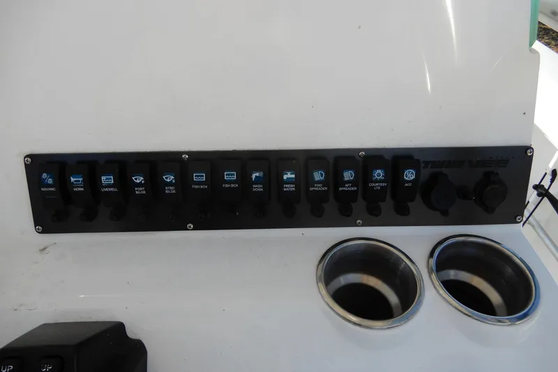 Slide: The Image of Control panel of 2022 Twin Vee 240 CC GFX Limited Edition boat with labeled switches. - 23