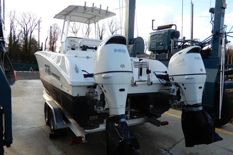Slide: The Image of 2022 Twin Vee 240 CC GFX Limited Edition boat with dual Suzuki 140 engines on trailer. - 4