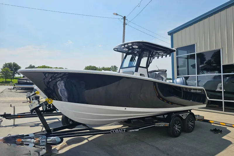 Slide: The Image of 2025 Sportsman Open 232 Center Console boat on trailer, parked outside a building. - 1