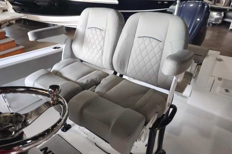 Slide: The Image of 2025 Sportsman Open 232 Center Console boat seats with diamond stitching and armrests. - 3