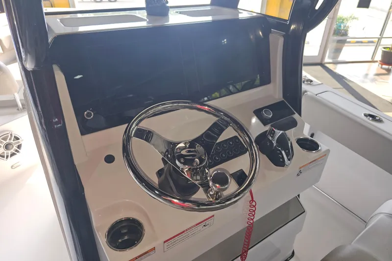 Slide: The Image of 2025 Sportsman Open 232 Center Console helm with steering wheel and controls. - 4