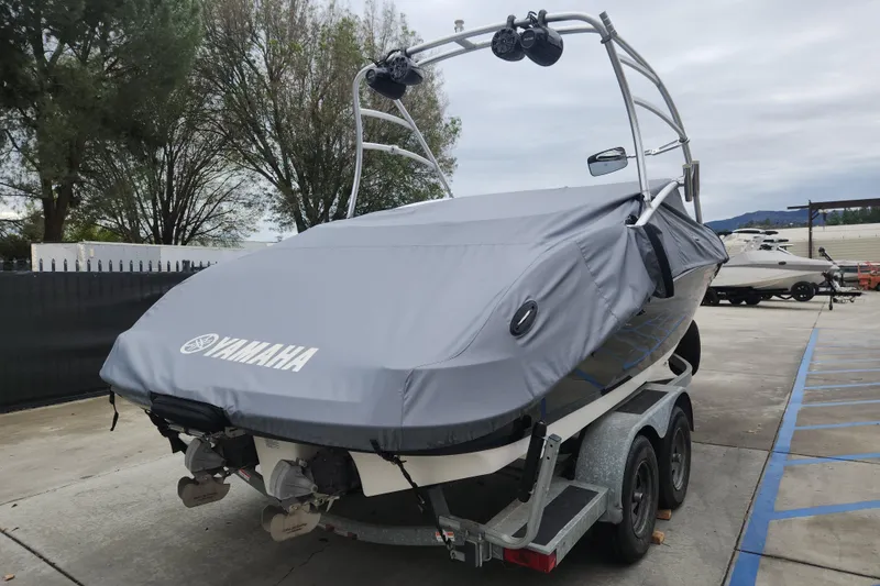 Slide: The Image of 2007 Yamaha AR210 boat covered on trailer, parked outdoors. - 2