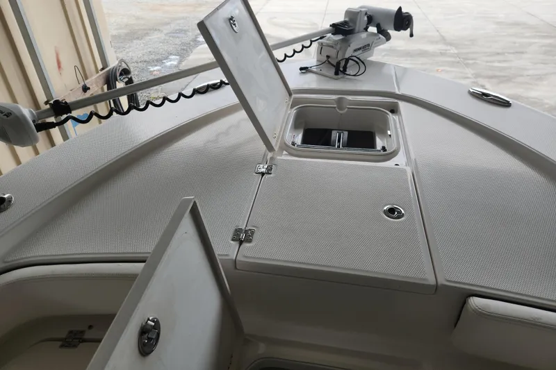Slide: The Image of 2024 Robalo 246 Cayman boat deck with open storage compartments and trolling motor. - 3
