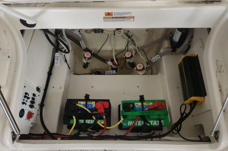 Slide: The Image of 2024 Robalo 246 Cayman boat battery compartment with wiring and components. - 5