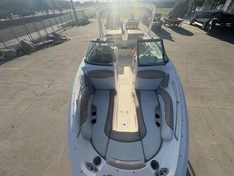 Slide: The Image of 2013 Rinker Captiva 276 boat with spacious seating, parked outdoors in sunlight. - 15