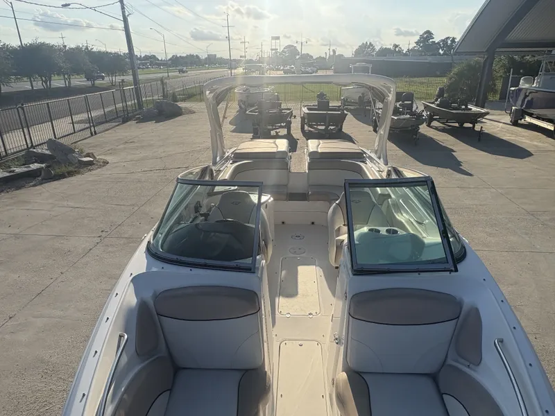 Slide: The Image of 2013 Rinker Captiva 276 boat with open seating, parked outdoors on a sunny day. - 16