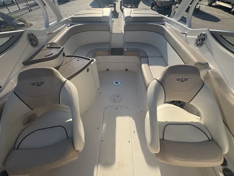 Slide: The Image of 2013 Rinker Captiva 276 boat interior with beige seating and storage compartments. - 6