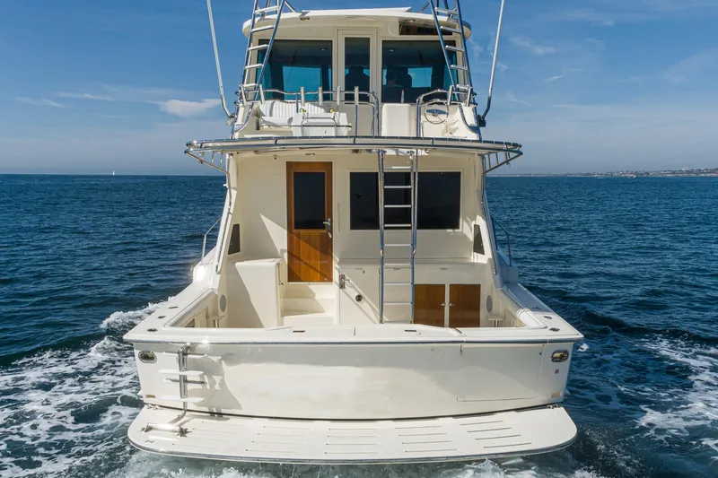Slide: The Image of 1991 Hatteras 58 Convertible yacht cruising on open water, rear view. - 4