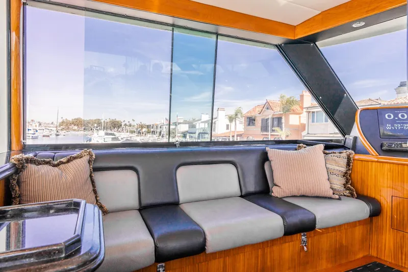 Slide: The Image of 1991 Hatteras 58 Convertible yacht deck with ladder, overlooking serene waterfront. - 40