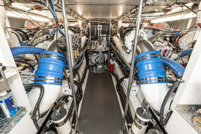 Slide: The Image of Engine room of 1991 Hatteras 58 Convertible yacht, featuring dual engines and blue piping. - 51