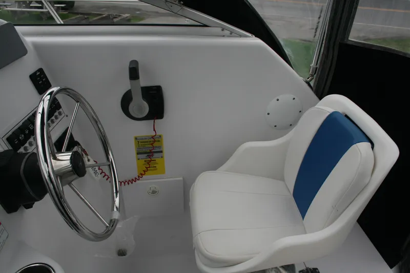 Slide: The Image of 2013 Pro-Line 20 Express boat interior with steering wheel and white-blue captain's chair. - 4