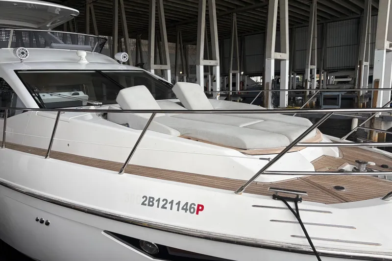 Slide: The Image of 2020 Azimut 55 yacht with sleek design and spacious deck in marina setting. - 2