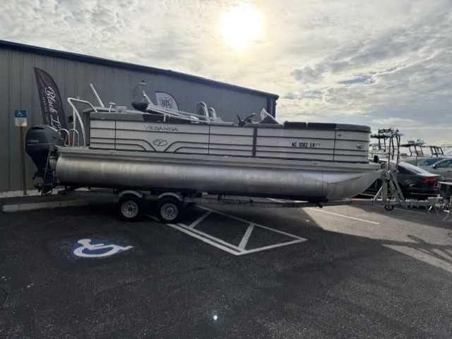 Slide: The Image of 2020 Veranda VTX22RC pontoon boat on trailer, parked outside a building under a cloudy sky. - 13