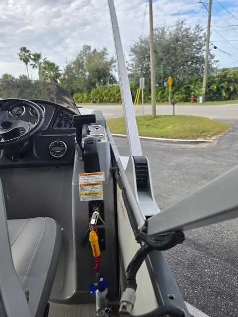 Slide: The Image of 2020 Veranda VTX22RC boat interior with steering wheel and control panel, parked outdoors. - 6