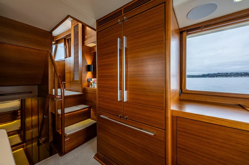 Slide: The Image of Luxurious interior of 2026 Fleming 55 Pilothouse yacht with wooden finishes and scenic window view. - 21
