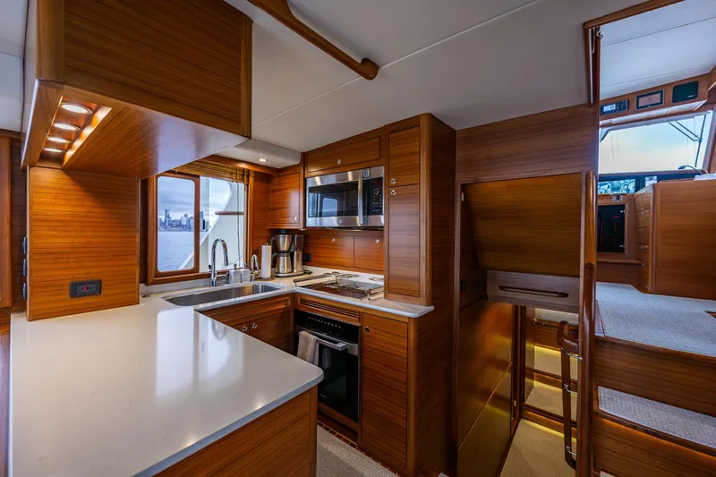 Slide: The Image of Luxurious kitchen interior of 2026 Fleming 55 Pilothouse yacht with modern appliances and wood finish. - 26