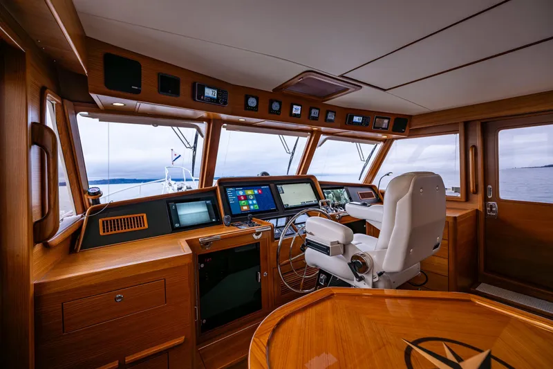 Slide: The Image of 2026 Fleming 55 Pilothouse yacht interior with modern navigation equipment and wooden finish. - 29