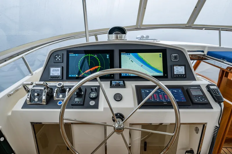 Slide: The Image of Pilothouse of 2026 Fleming 55, featuring advanced navigation systems and steering wheel. - 38
